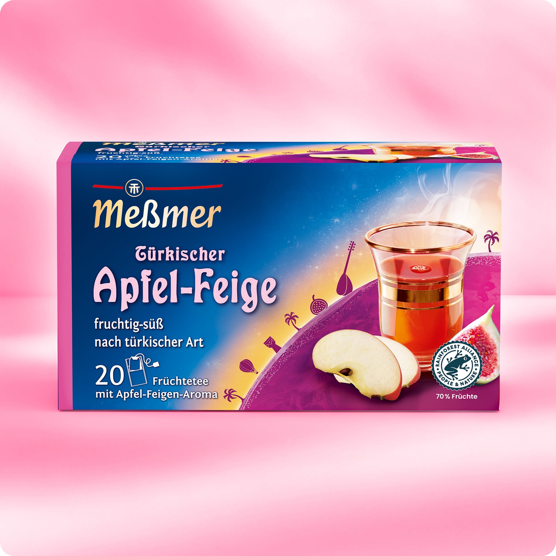 Eine farbenfrohe Schachtel Meßmer DE Türkischer Apfel-Feige Tee mit Apfel- und Feigenscheiben, türkisch inspirierten Motiven und einem Glas Früchtetee steht auf einem rosa Hintergrund. Die Schachtel enthält 20 Teebeutel.