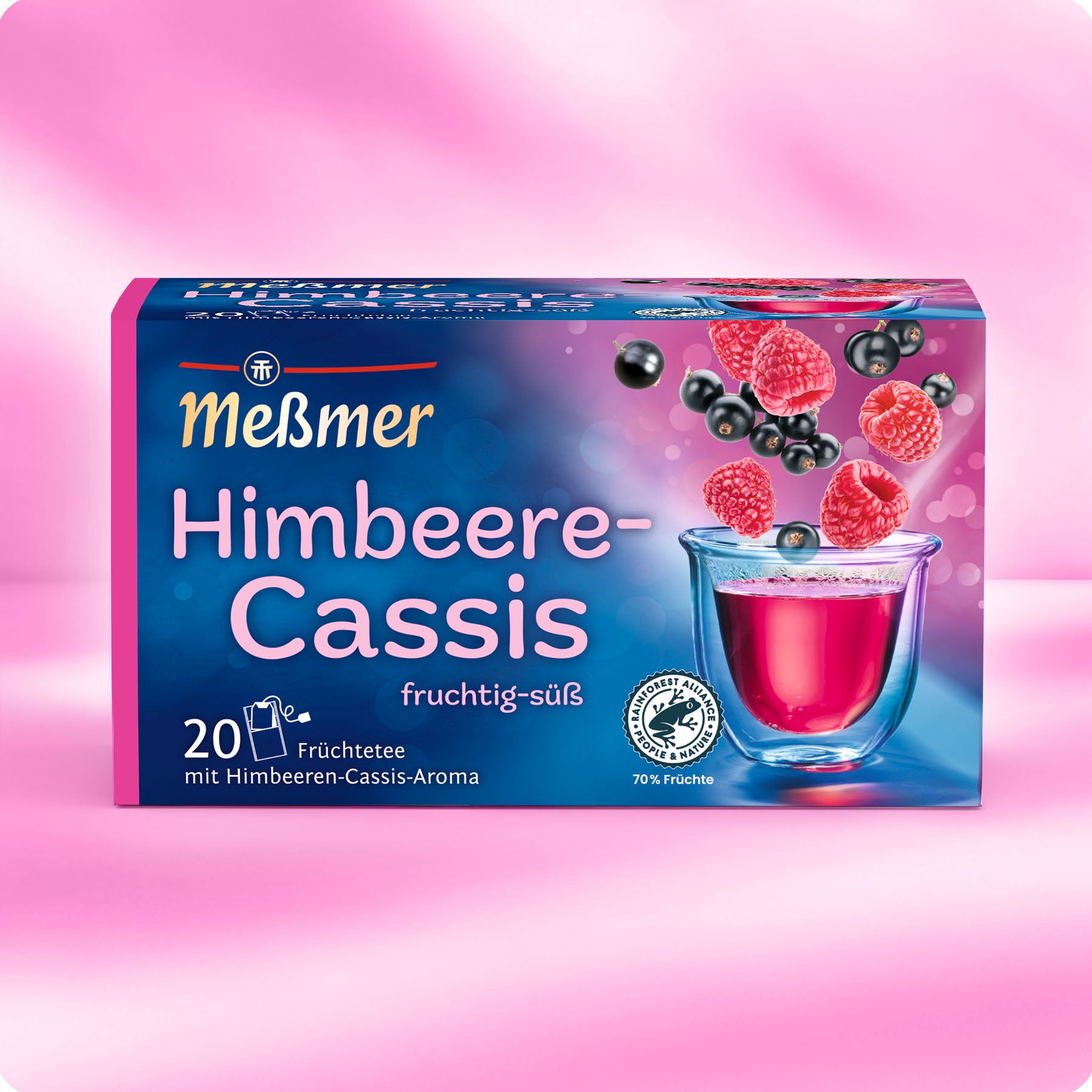 Meßmer Himbeere-Cassis Früchtetee Verpackung mit frischen Himbeeren und schwarzen Johannisbeeren über einer gläsernen Tasse mit rotem Tee auf rosa Hintergrund.